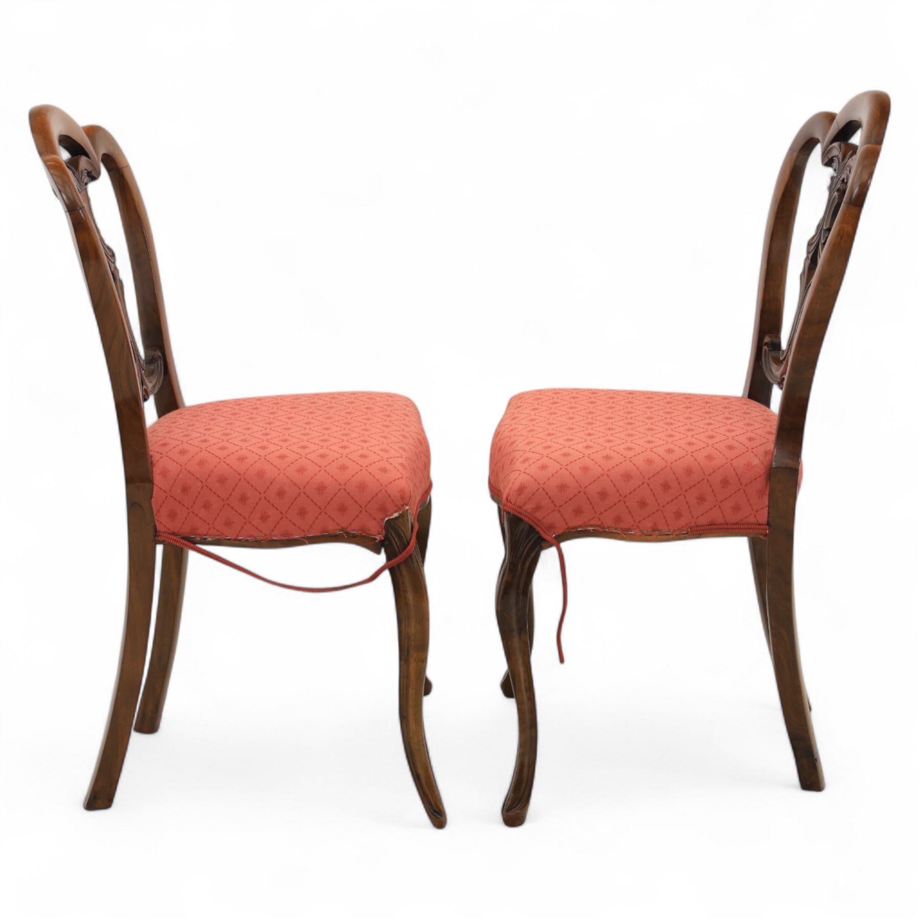 Set of four Victorian walnut balloon back chairs, with a carved and pierced back splat with foliate scrolls, serpentine seat upholstered in a diamond pattern fabric, raised on cabriole legs 