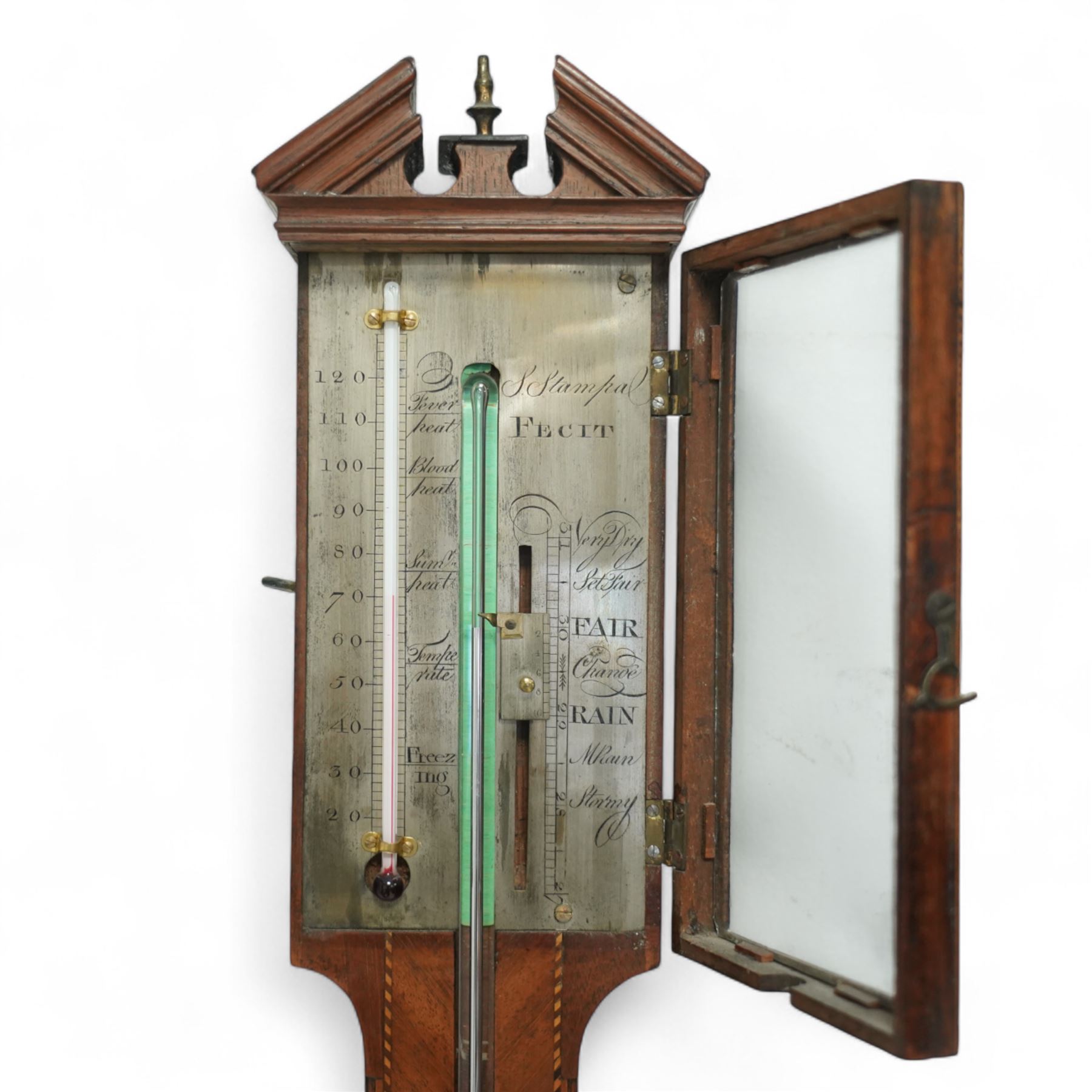 Stampa- George III early 19th-century mercury stick barometer in a mahogany case with a broken pediment and round base, case with chequered inlay to the edge and cistern cover, visible full length bulb cistern tube recording barometric air pressure from 27 to 31 inches with predictions, rectangular silvered register and vernier, with a spirit thermometer indicating the temperature in degrees Fahrenheit.
Mercury present in good condition.
Stampa is recorded as working in London as a barometer and looking glass manufacturer.