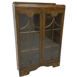Early 20th century oak bookcase or display cabinet, raised back over two astragal glazed doors with carved decoration, enclosing two shelves