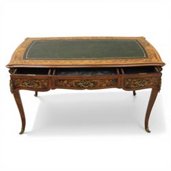 Late 19th century French kingwood and marquetry bureau plat, the serpentine rectangular top with green leather inset writing surface within crossbanded and foliate marquetry border, above a shaped frieze fitted with three drawers with floral marquetry panels and gilt metal handles, upon cabriole supports with applied gilt metal mounts and sabots