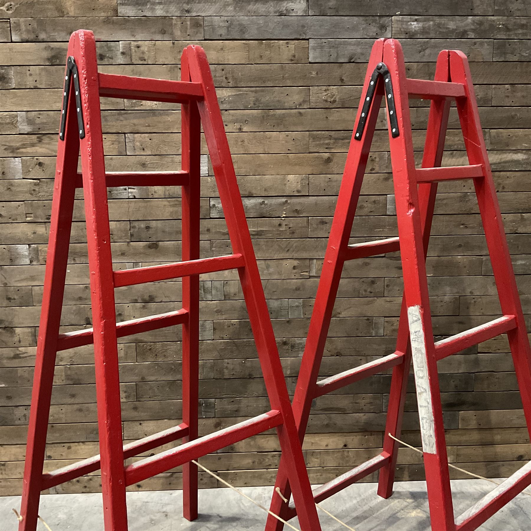 Pair of vintage red painted A frame trestles, with original A W Oates Painter signage