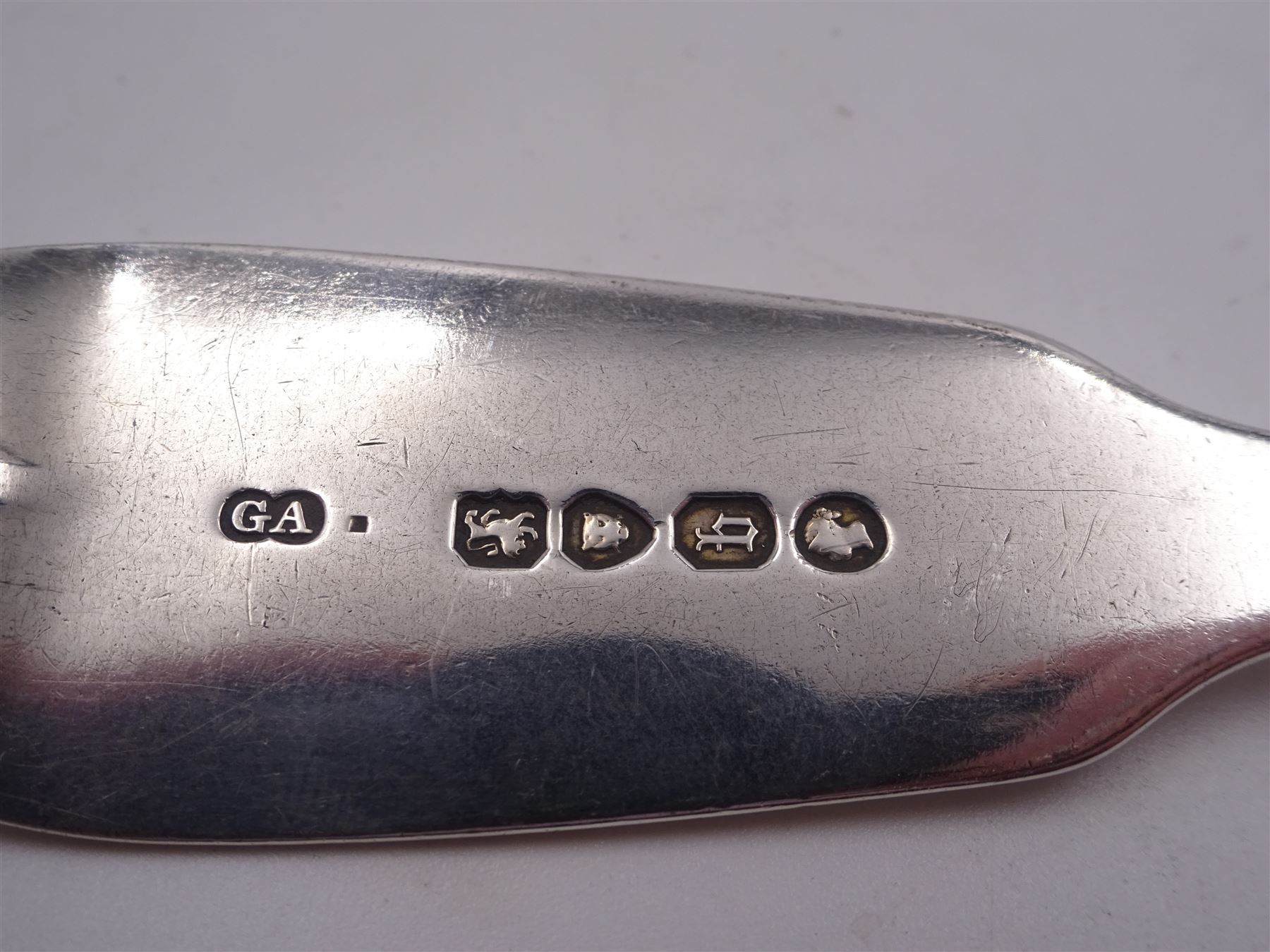 Group of Victorian silver fiddle pattern spoons, comprising pair of sauce ladles and set of six teaspoons, both hallmarked Henry Holland (of Holland, Aldwinckle & Slater), London 1857, set of four table spoons, hallmarked Chawner & Co (George William Adams), London 1857, and set of six dessert spoons, hallmarked Chawner & Co (George William Adams), London 1856, with monogrammed terminals, approximate total silver weight 25.50 ozt (792.6 grams)