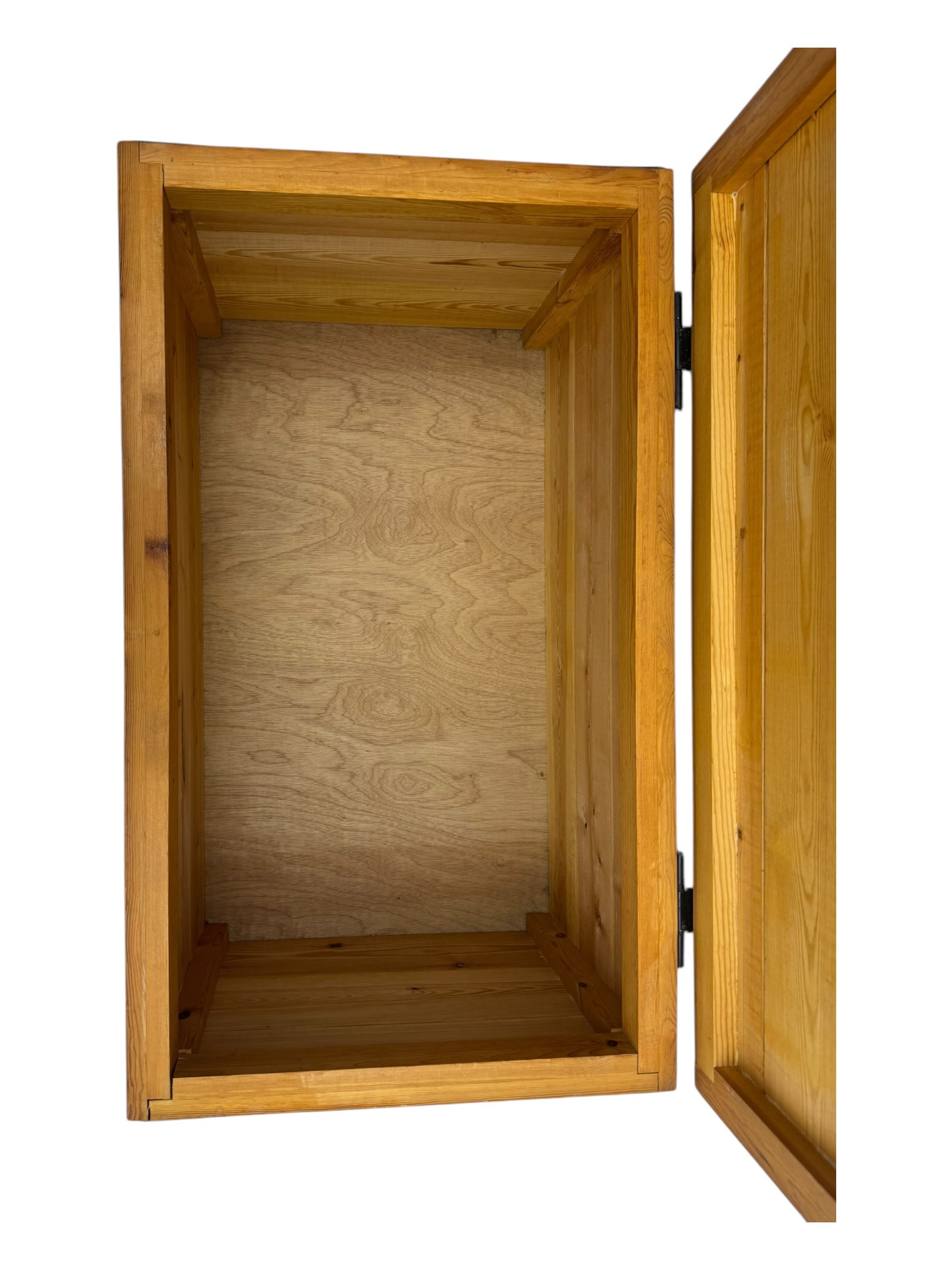 Contemporary polished pine blanket chest, the hinged planked lid with iron strap hinges and clasp fitting, plain boarded sides, fitted with blackened metal drop handles, on a moulded plinth base
