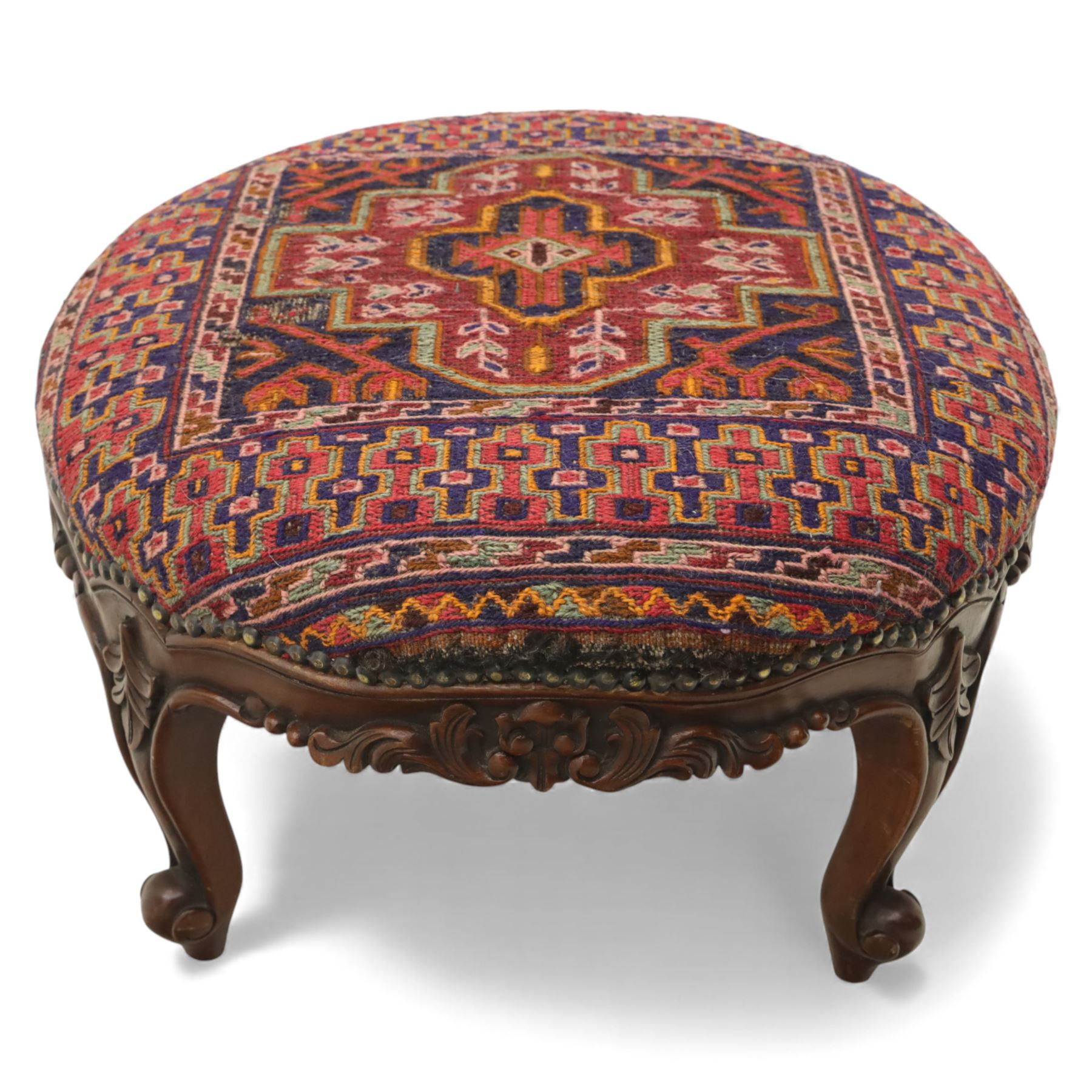 Two upholstered and caned footstools, a late Victorian carved mahogany footstool, oval form upholstered in geometric kilim-style fabric, on cabriole supports (H 27cm, W 56cm, D 47cm), together with a 20th century beech stool, square caned seat on turned supports united by stretchers (H 43cm, W 44cm, D 37cm)