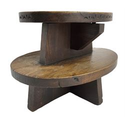 20th century figured elm occasional table, two oval tiers raised on cruciform base, the top tier carved with incised decoration 