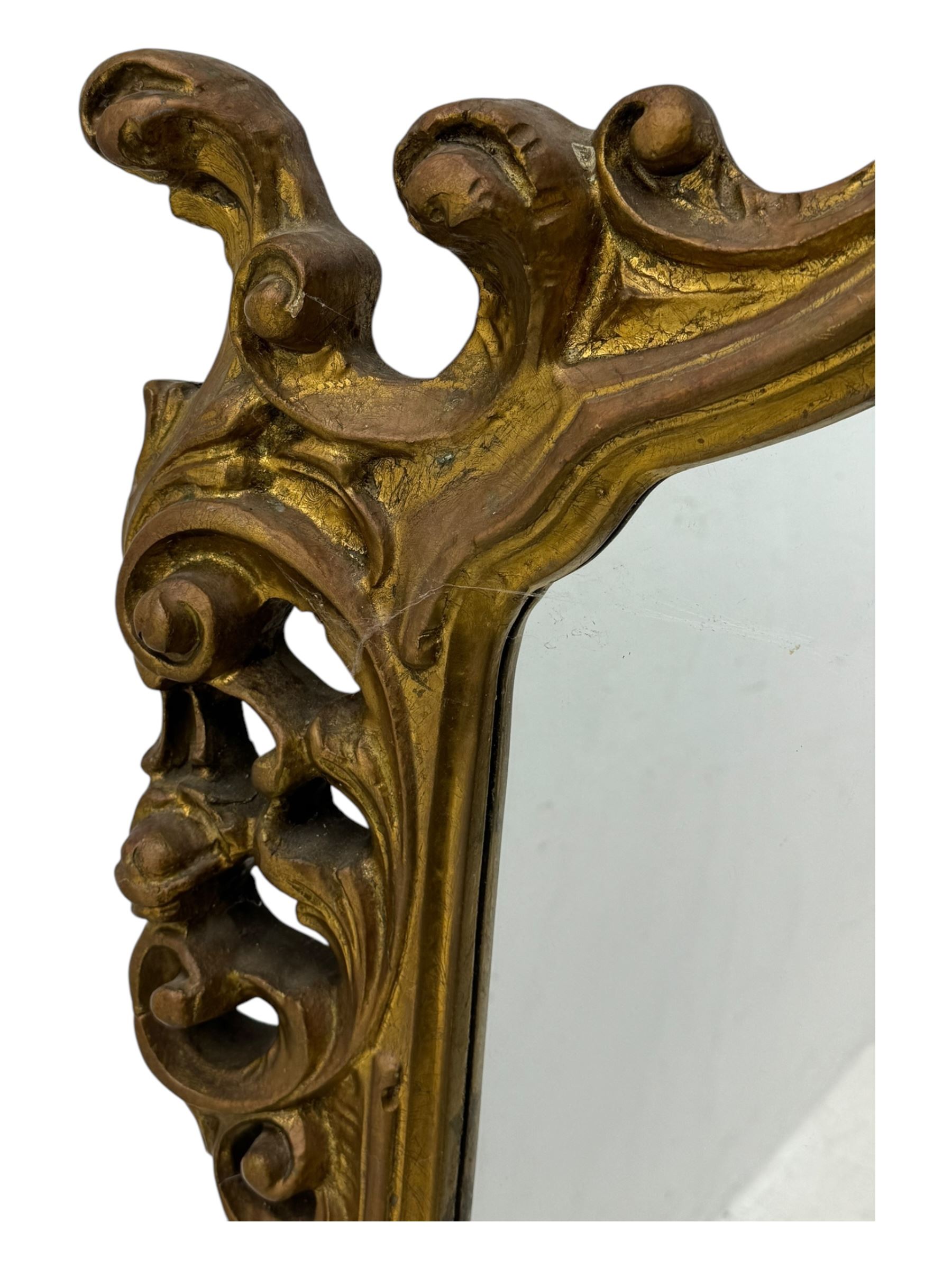 Victorian design gilt framed overmantel mirror, the arched and moulded frame adorned with scrolling foliate motifs and acanthus leaves, surmounted by a pierced cartouche, plain mirror plate, resting on a shaped base