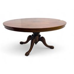 Victorian mahogany breakfast loo table, oval tilt-top on turned pedestal, quatrefoil out-splayed carved supports, scroll carved terminals with brass castors