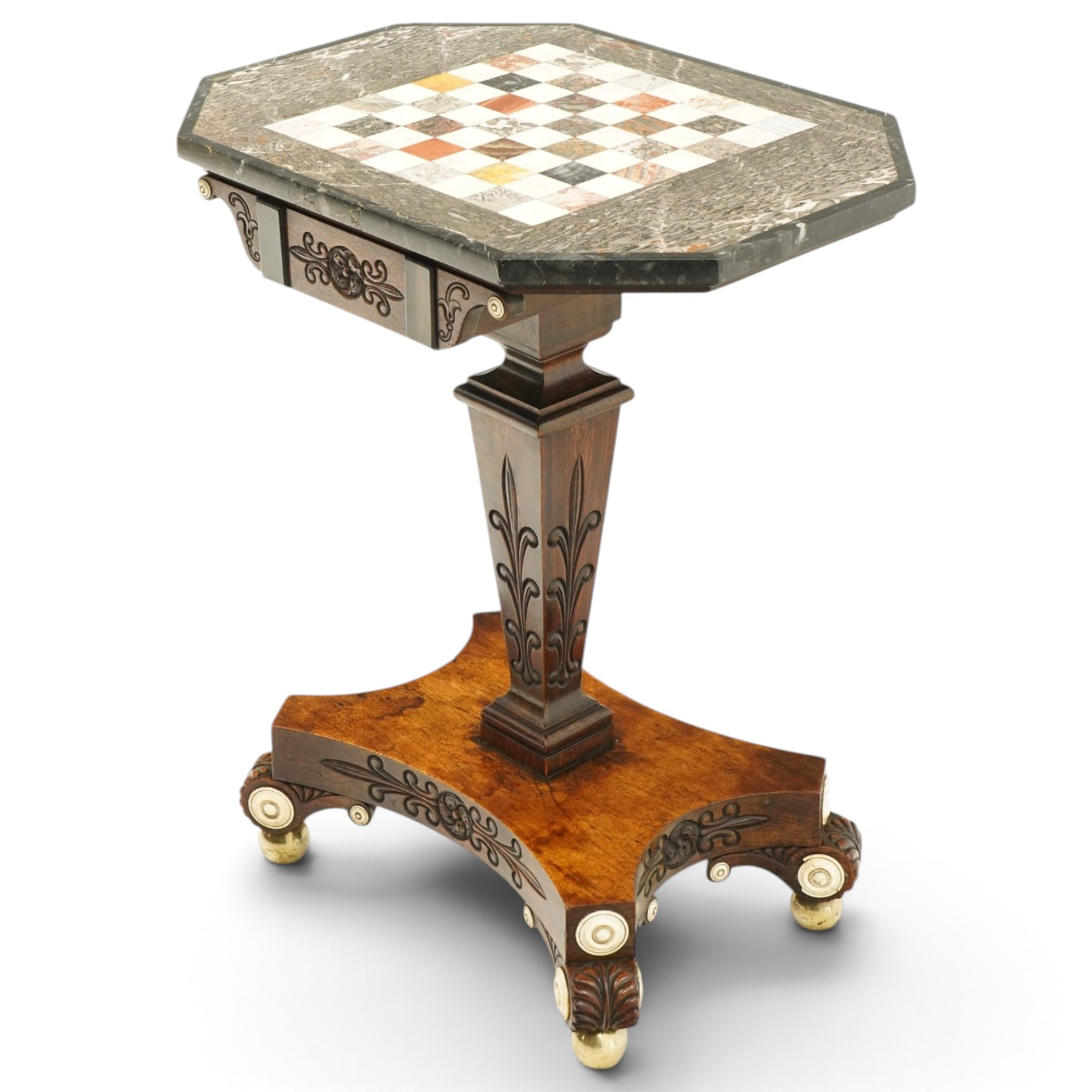 Early 19th century Anglo-Indian rosewood and specimen marble chess table, the octagonal top inset with a chequerboard of various coloured marbles within a broad fossil marble border and black marble edge, over a foliate and rosette carved frieze and turned-and-tapering pedestal with lotus-carved decoration, on a concave-sided quadripartite platform base with anthemion carved scroll terminals, inset ivory roundels and brass bun feet