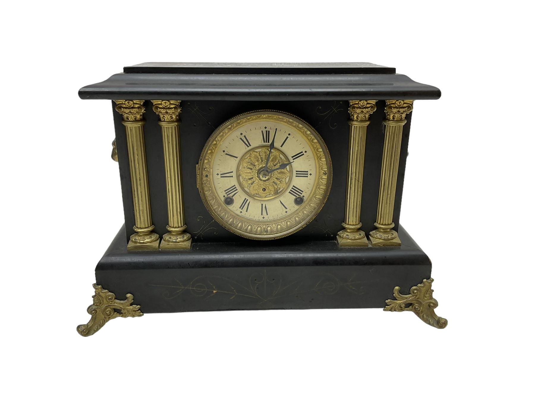 Seth Thomas - American 8-day late 19th century faux slate mantle clock, wooden case with a flat top, decorative gilt metal columns, lion heads and splayed feet,  two part dial with a gilt centre and Roman numerals to the chapter, within an ornate glazed bezel, twin train spring driven movement striking the hours on a coiled gong and the half hours on a bell. 