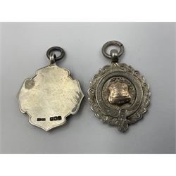 Seven early 20th century silver gold faced cartouche fobs, to include a circular example, with rose gold border and cartouche within an embossed yellow gold border, engraved verso, and a double sided example, all hallmarked with various dates and makers
