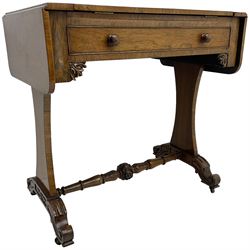 Regency rosewood writing table, rectangular drop-leaf top with rounded corners, hinged easel centre with inset leather writing surface, fitted with single cock-beaded drawer, foliage carved corner brackets, on waisted end supports with scroll carved out-splayed feet, central turned stretcher carved with acanthus leaves and flowerheads 