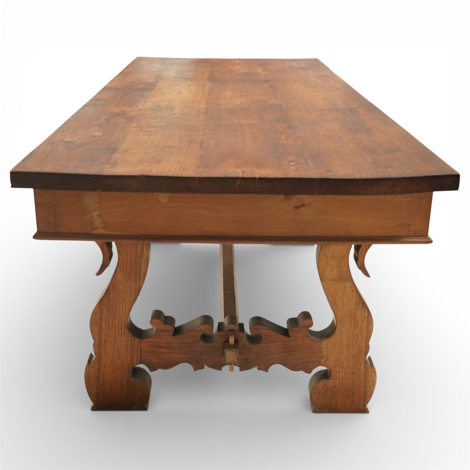 20th century Spanish design oak dining table, large rectangular top above a run of three drawers to the frieze, standing on shaped trestle supports with scroll cut details and stretcher base