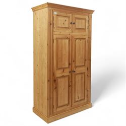 Modern stripped pine triple wardrobe, with stepped cornice over upper cupboard doors and t...