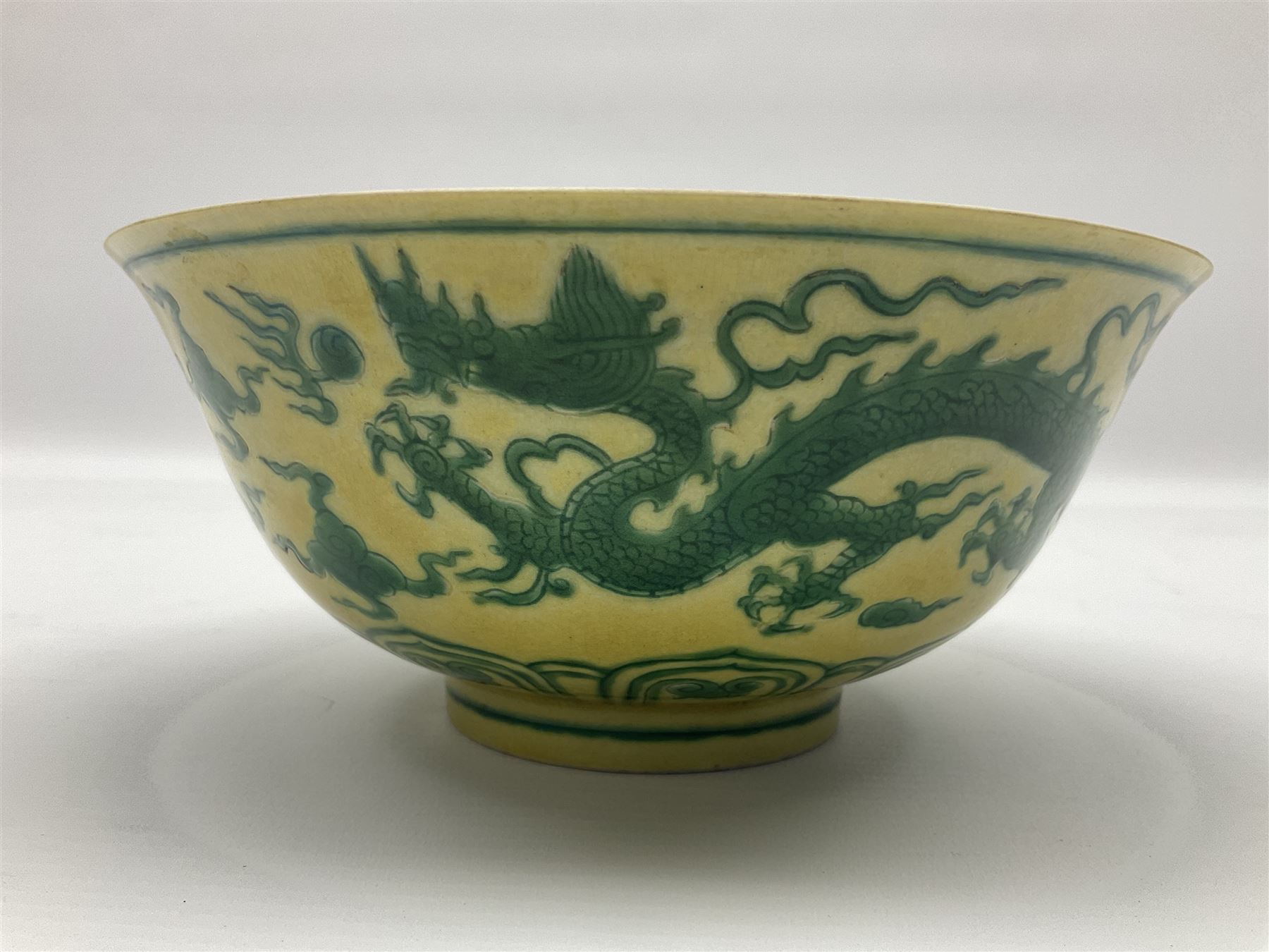 Pair of Chinese famille jaune bowls, decorated in green enamel with a dragon chasing a flaming pearl amongst clouds, upon a yellow ground, the interior decorated to centre with dragon, with six character mark beneath, D17.5cm