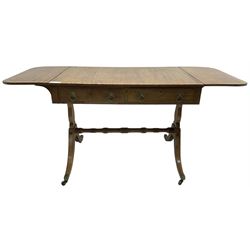 Regency mahogany sofa table, rectangular crossbanded top with twin drop-leaf ends, fitted with single drawer and one faux drawer, raised on shaped end supports united by ring turned stretcher