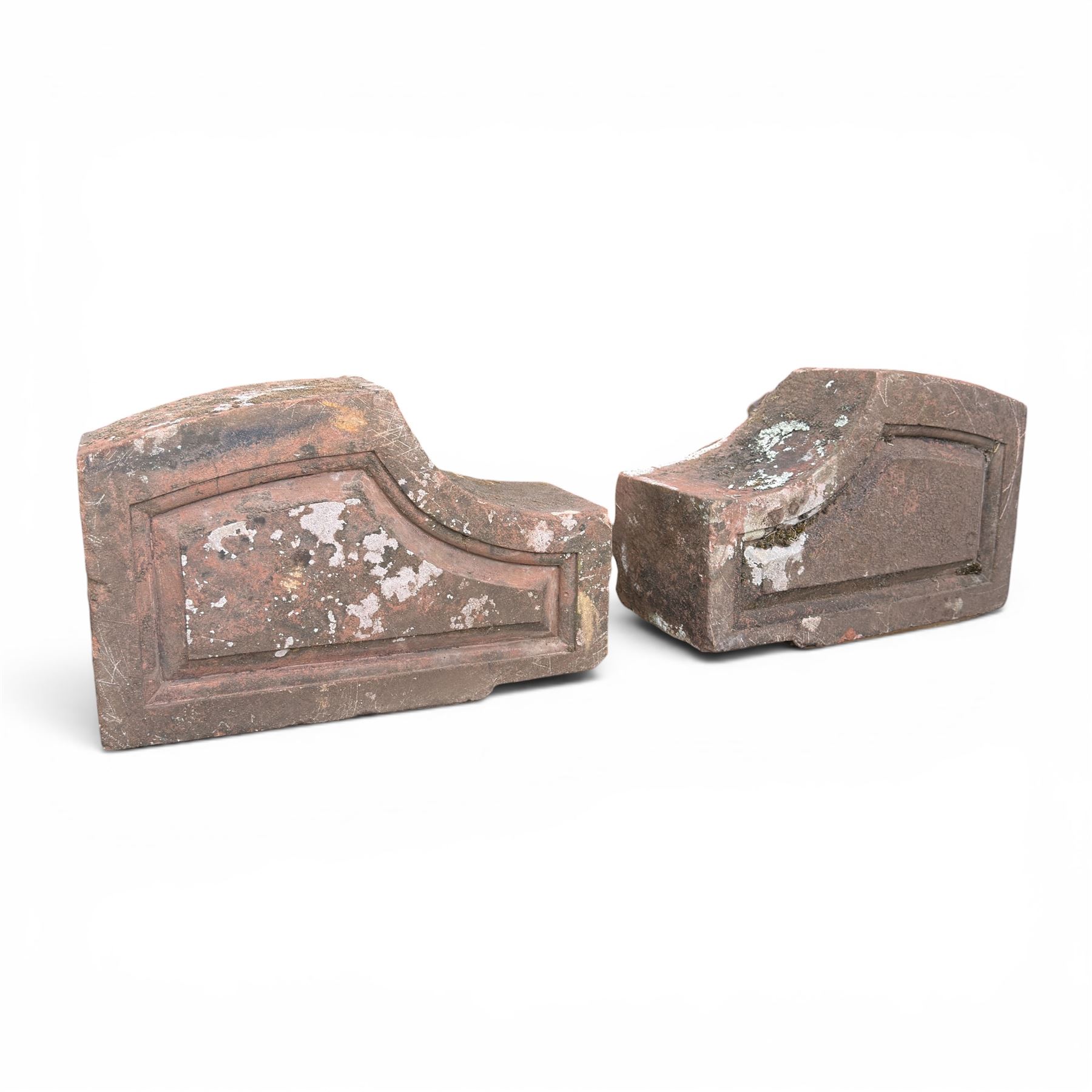 Pair of 19th century hewn and carved stone wall ends, the facias carved as shaped faux fielded panels