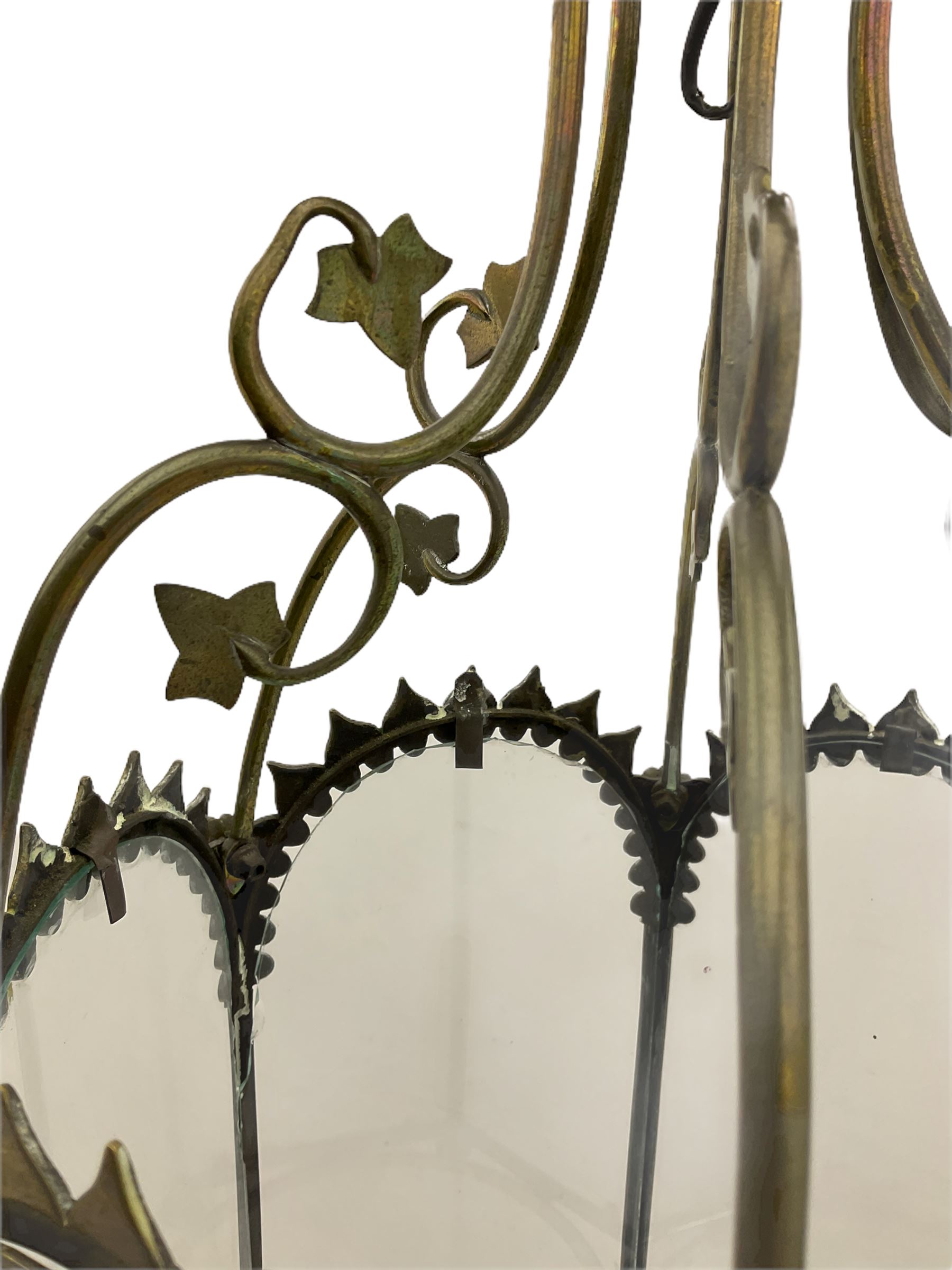 19th century brass and clear glass hexagonal hall lantern, with scrolling wire work open domed top over six arched panels, including a hinged door, the base enclosed with a circular glass panel on turned feet, H64cm