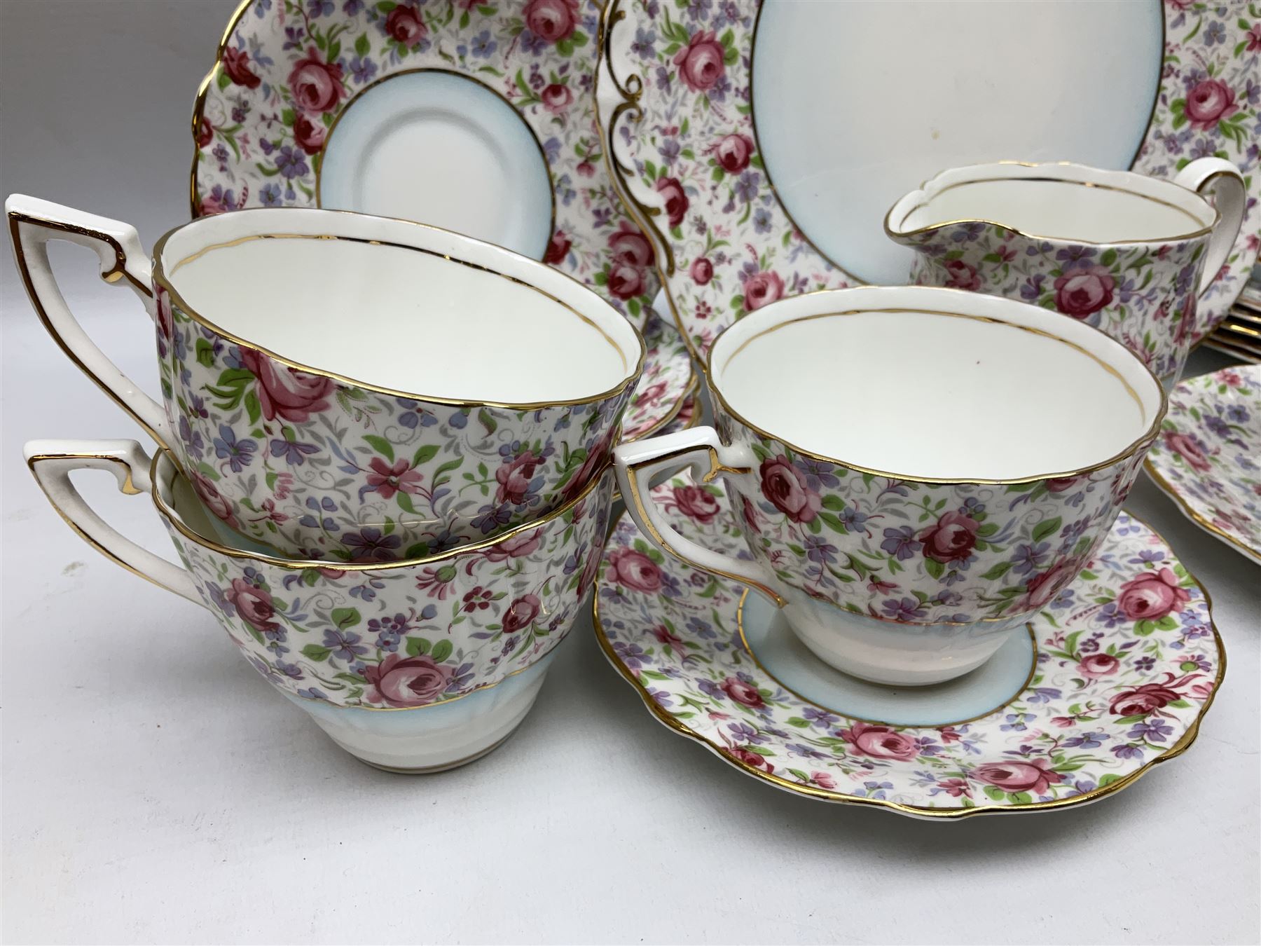 Windsor tea service for six decorated with blooming pink roses and purple flowers amongst foliage