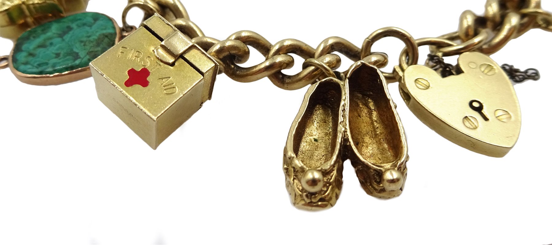 9ct gold curb bracelet with heart locket hallmarked,  with ten 9ct gold charms including stork carrying a baby, house, first aid box and an 18ct gold cross charm, all tested, hallmarked or stamped
