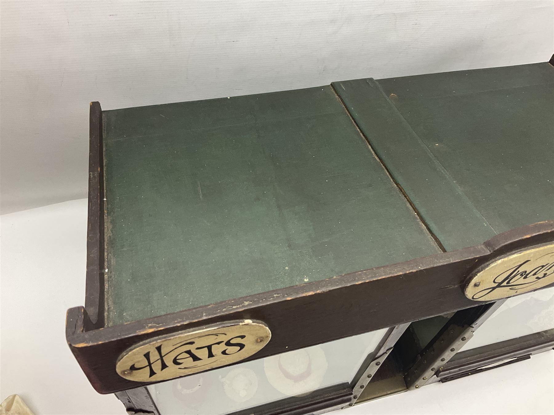 Early 20th century scratch-built wooden hat & gown shop diorama 'Joan', of double-fronted form glazed on three sides with brass and aluminium mounts, rear access apertures and storage under L63cm H45cm D31cm; with small collection of dresses and hats on display stands