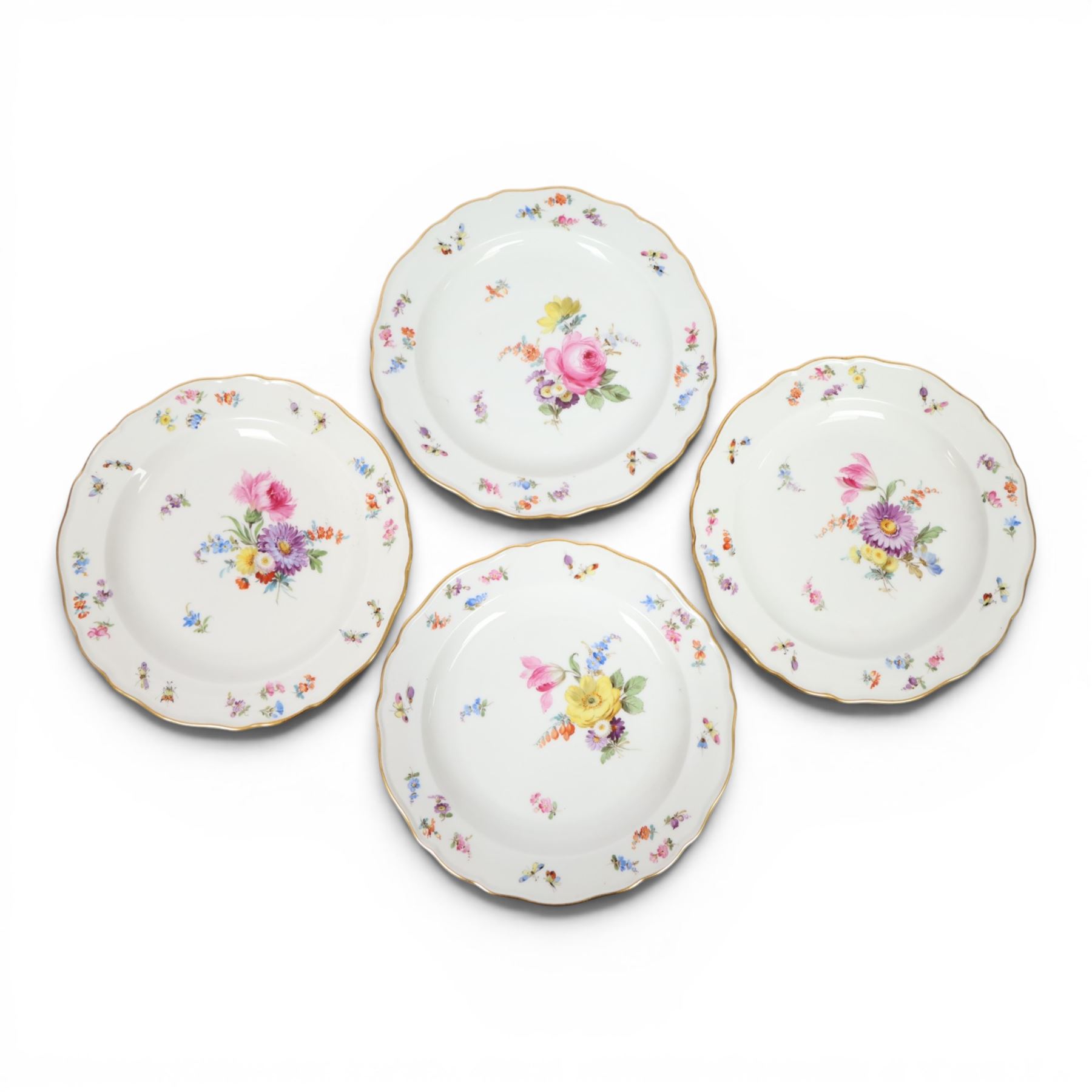 Four early 20th Century Meissen plates, hand painted with floral sprays, sprigs and inspects, with underglaze blue cross sword mark beneath, D21.5cm