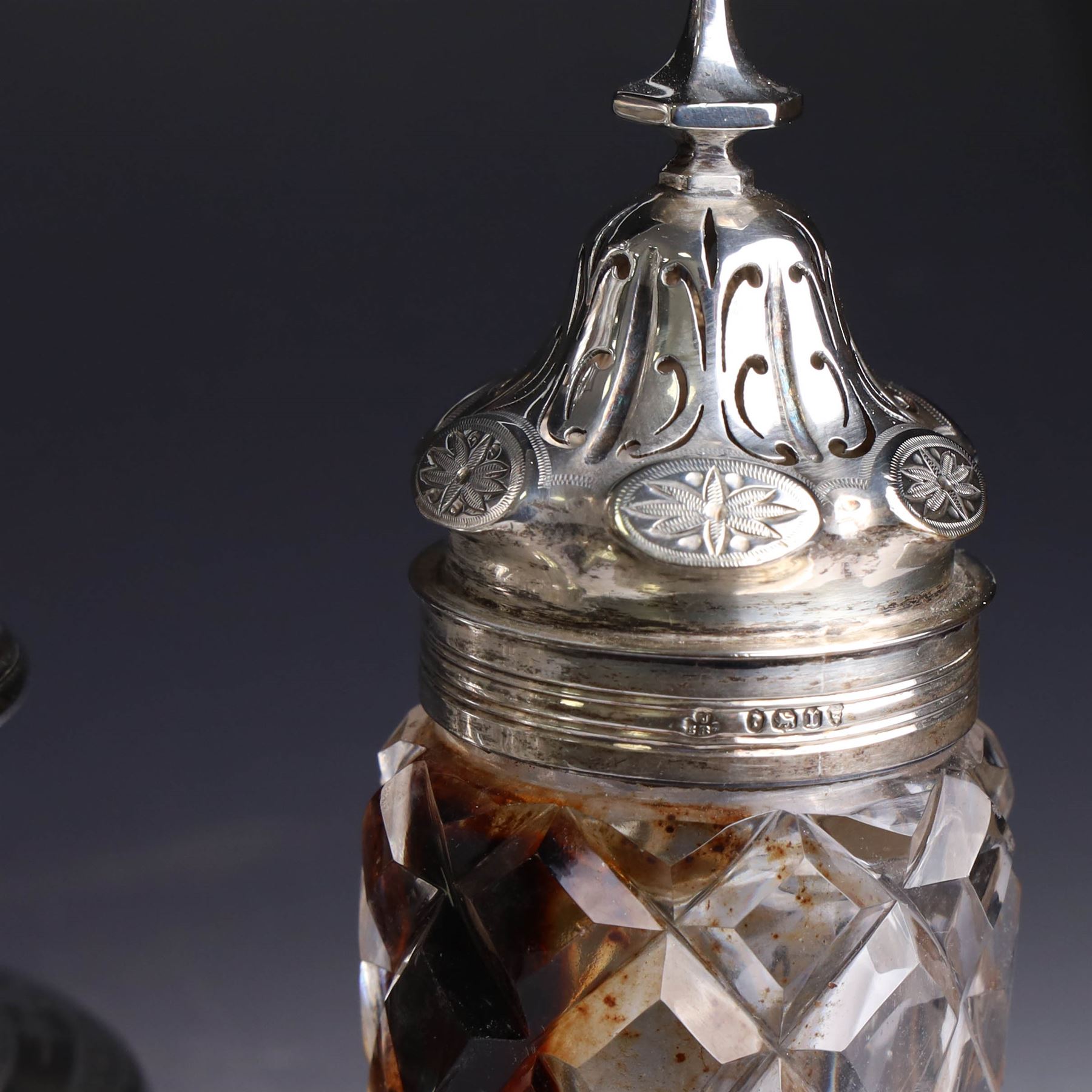 Victorian silver cruet stand, containing eight cut glass cruet bottles, four with silver covers, upon a shaped base with four scroll feet and loop handle, chased with floral and foliate decoration, the stand, base and bottle caps all hallmarked John, Edward, Walter & John Barnard, London 1872, one bottle with a matched silver cruet spoon, stand H30cm