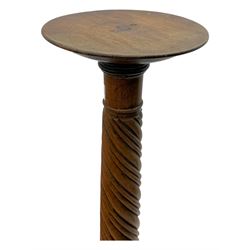 Late 19th century mahogany torchère stand, with circular top above a twisted and foliate carved collumn, on a scroll carved tripod base, on cabriole legs
