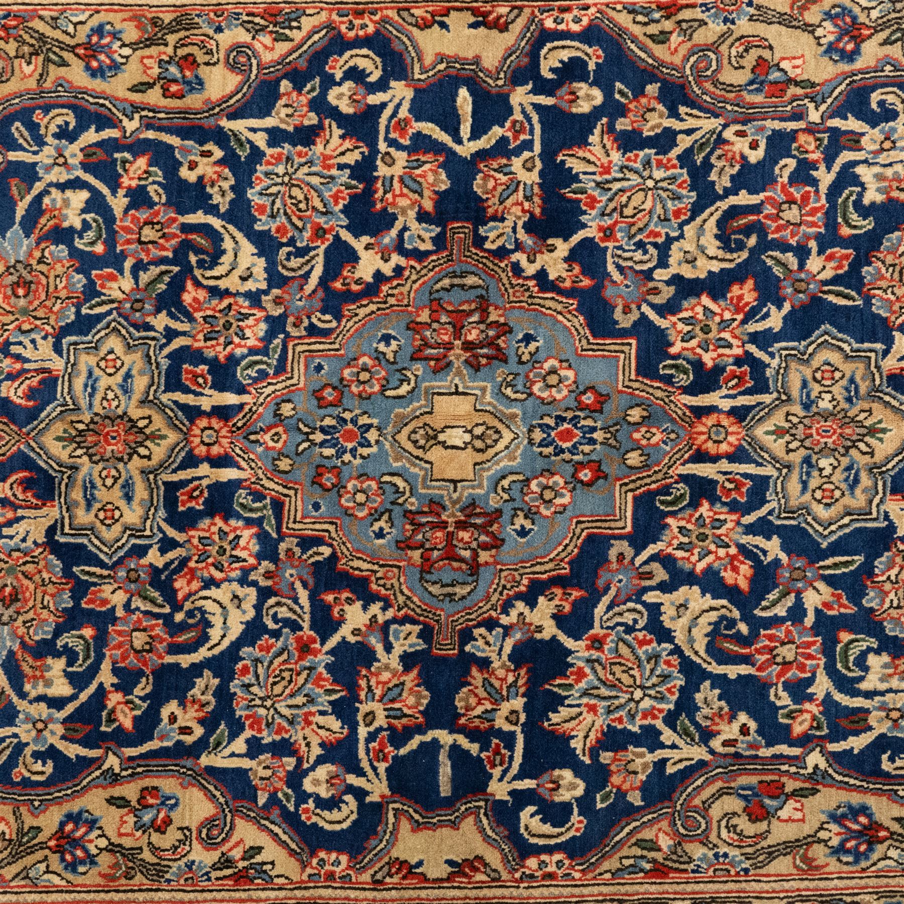 Persian Kashan rug, navy field with lobed central medallion and scrolling floral sprays, ivory spandrels within a palmette and vine border