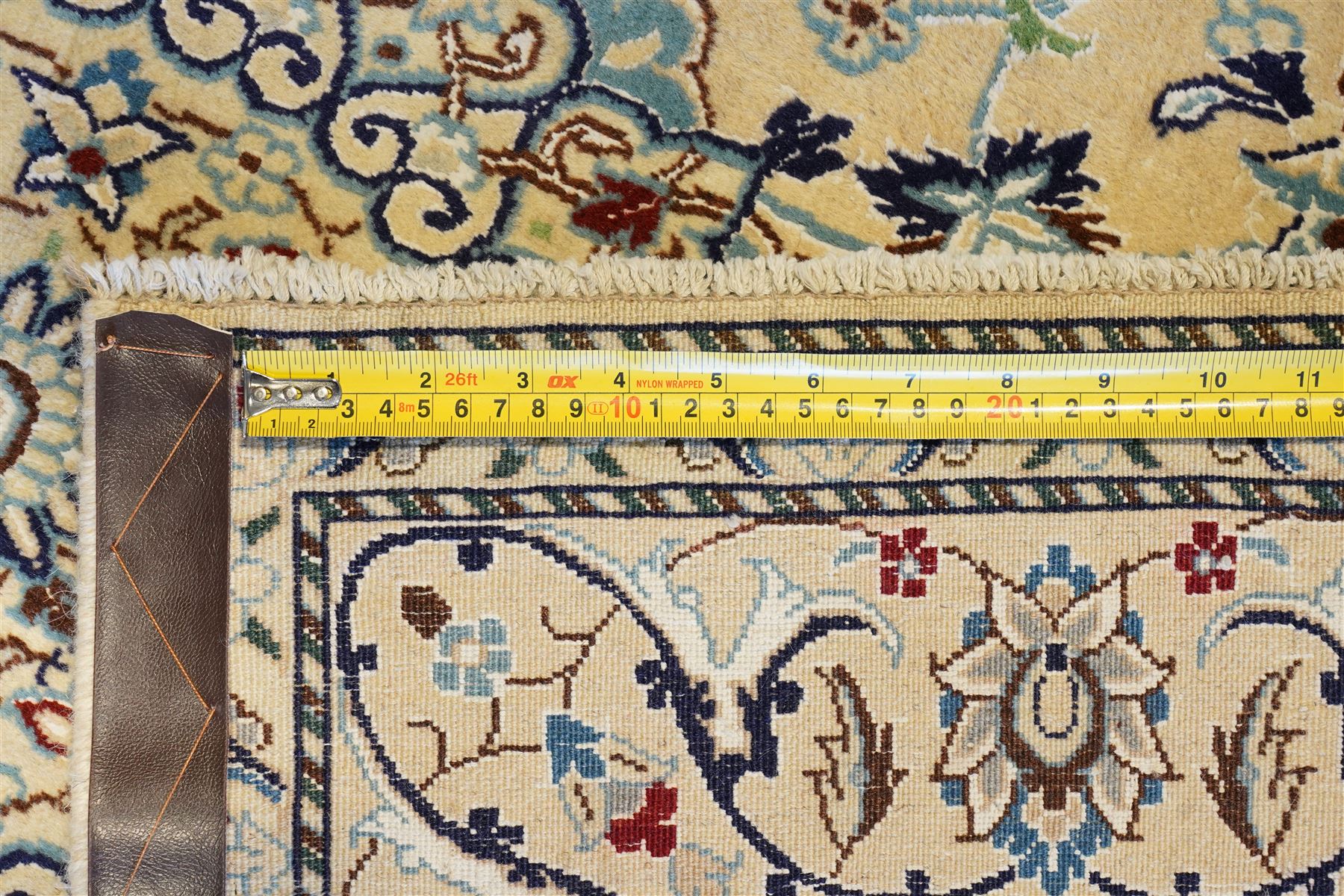 Central Persian Nain hand-knotted silk and wool rug, ivory field with a cusped medallion  issuing radiating pendants, with an all-over design of scrolling arabesques, palmettes and floral sprays, framed main border of meandering vinery and stylized palmettes, flanked by narrow guard stripes, cotton fringe ends  