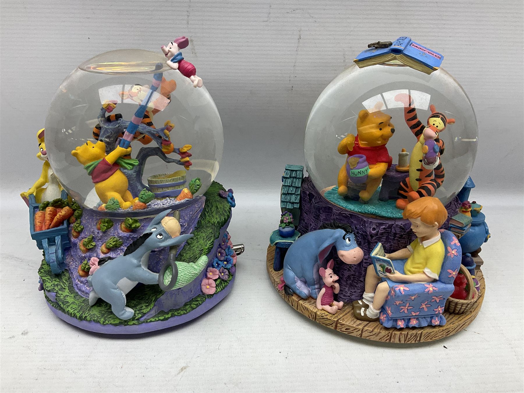 Five Disney Winnie The Pooh snow globes, to include Pooh and Piglet Sailing, Pooh's Grand Adventure and Blustery Day, together with The Walt Disney Classic Waterglobe collection globe and group Tigger, Winnie and Piglet figure under dome, all with boxes (7)