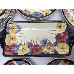 Early 20th century Art Deco Royal Doulton Pansies pattern octagonal teawares, comprising three larger teacups and saucers, three smaller teacups and saucers, open sucrier, two jugs, slop bowl, six side plates, two larger plates, two small circular dishes and one long twin handled rectangular dish, all with printed marks beneath, Rd No 597783, pattern no D4049