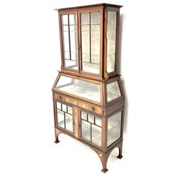 Art Nouveau inlaid mahogany bijouterie display cabinet, projecting cornice, bevel edge astragal glazed doors, lined interior, single fall front unit above single drawer, stile supports 