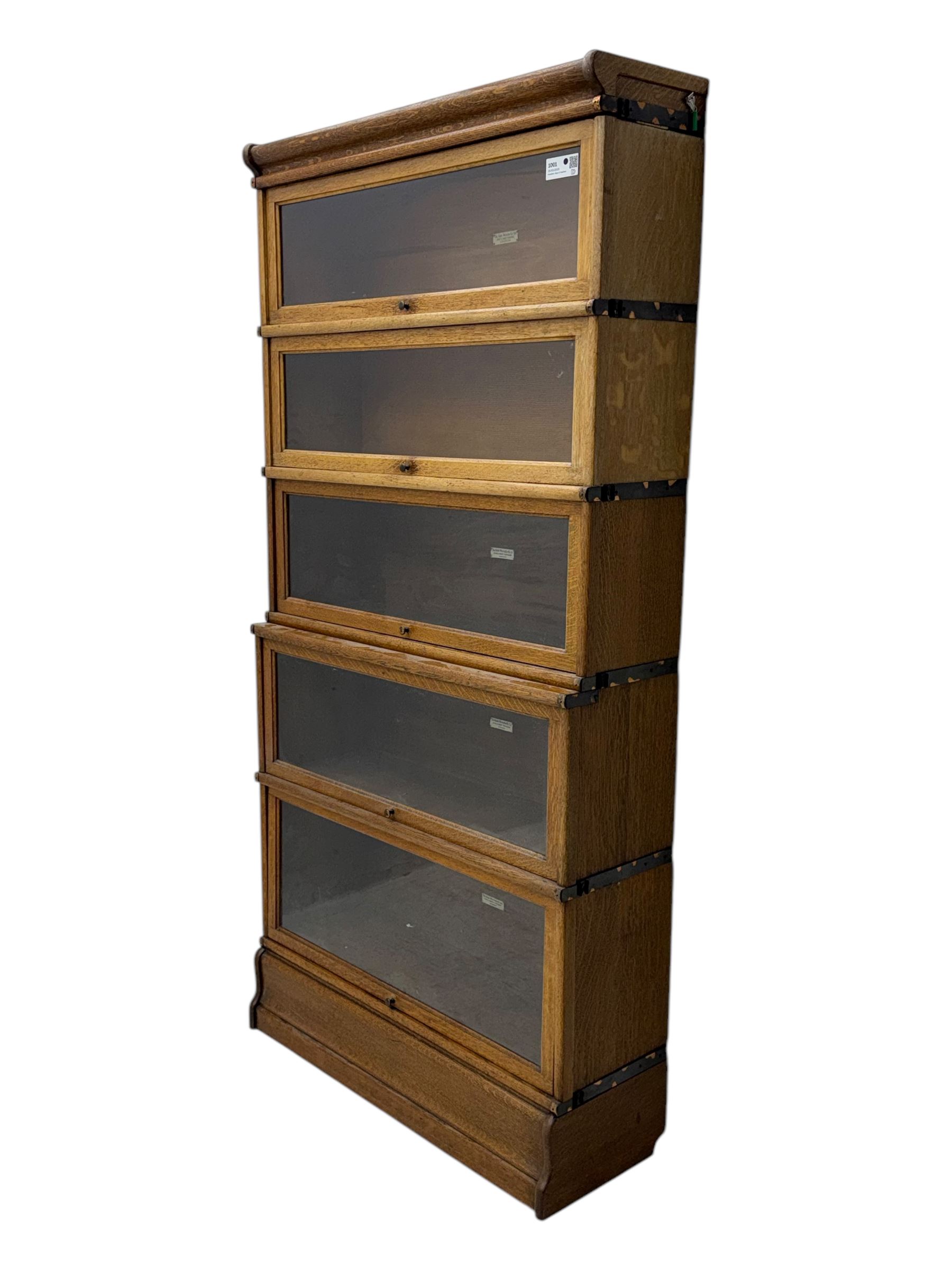 The Globe Wernicke Co. Ltd. - early 20th century oak five-tier stacking library bookcase, each section enclosed by hinged and sliding glazed door, on shaped plinth base 