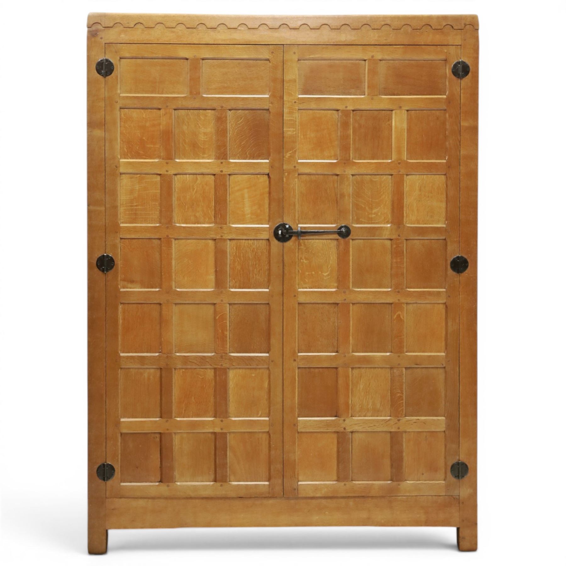 Mouseman - early-to-mid-20th century panelled and adzed double wardrobe, the arcade carved cresting rail over two panelled doors, with wrought metal hinges and latch, deep relief carved mouse signature, the interior fitted with hanging rail, by the workshop of Robert Thompson of Kilburn