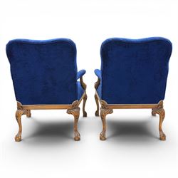 Pair of George II design Gainsborough armchairs in deep blue upholstery, shaped back over scrolled and carved arms, with cabriole supports and carved shell knees terminating in claw on ball feet