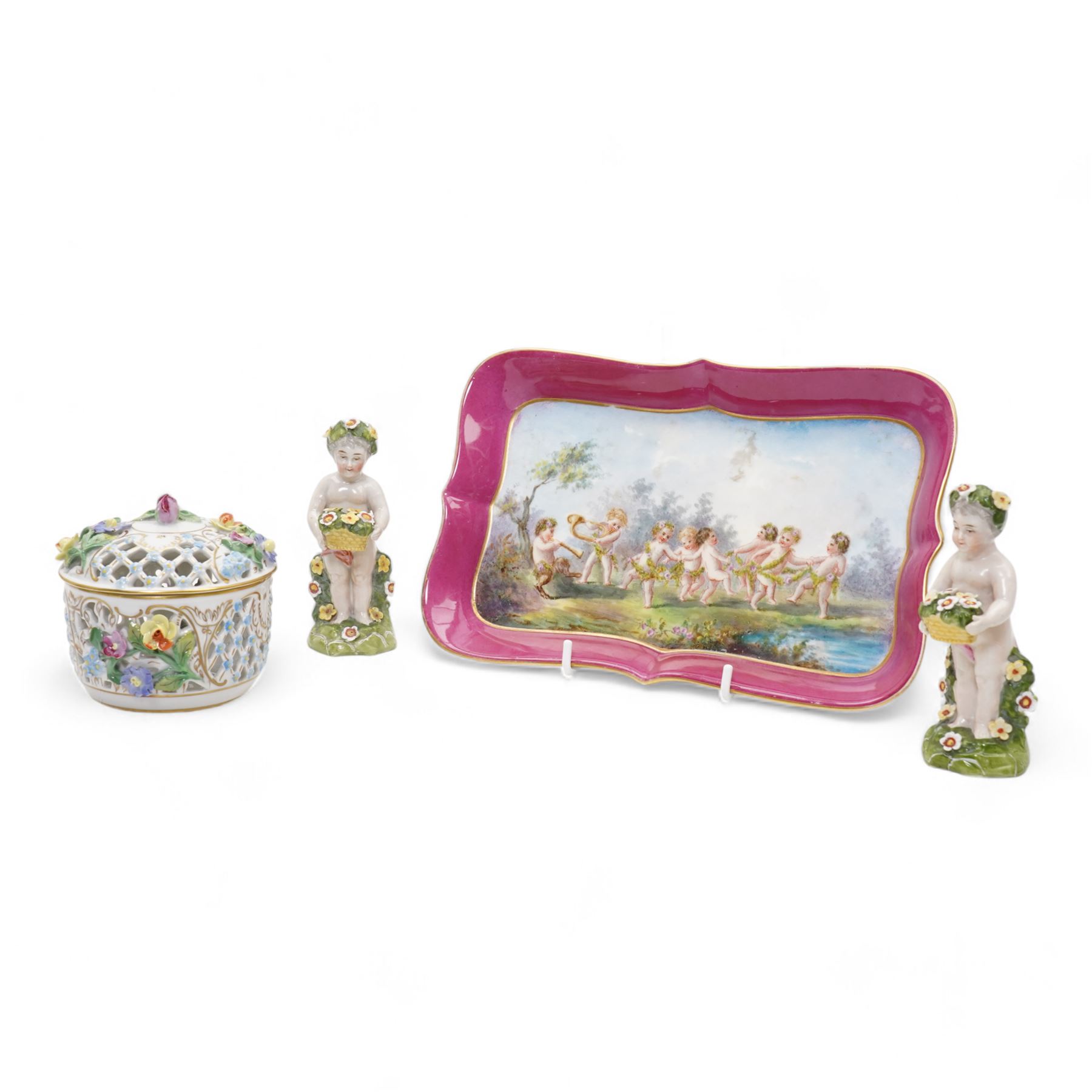 Early 20th century French porcelain tray, hand painted with dancing cherubs, within a pink and gilt border, inscribed 476 beneath, L25.5cm, pair of continental cherub figures, with blue anchor marks beneath, together with a Dresden porcelain pot pourri and cover, with pierced and floral decoration (4)