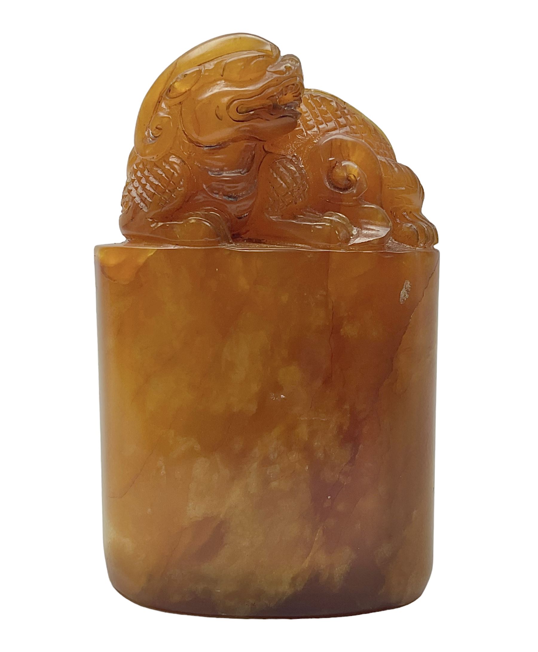 Chinese amber soapstone seal of oval form,  carved temple dog finial, inscription on the back and base, H12cm