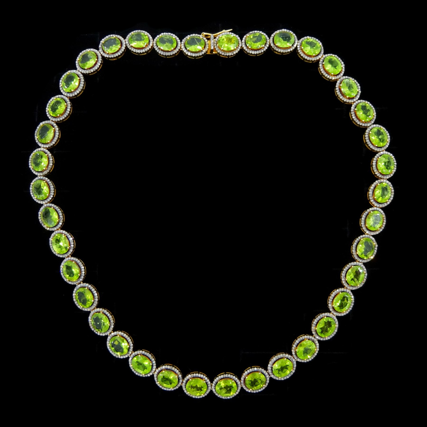 Silver-gilt peridot and diamond necklace, thirty-eight clusters, each set with a single oval cut peridot and round brilliant cut diamond surround, total peridot weight approx 57.00 carat, total diamond weight approx 5.00 carat