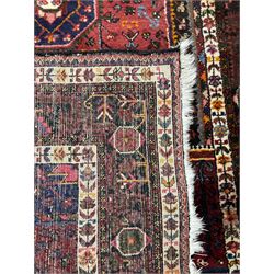 Persian Hamadan red and blue ground rug, the field with extending lozenge decorated with small stylised flower head motifs, the spandrels decorated with tree of life motifs, within a multi-band border with overall geometric design
