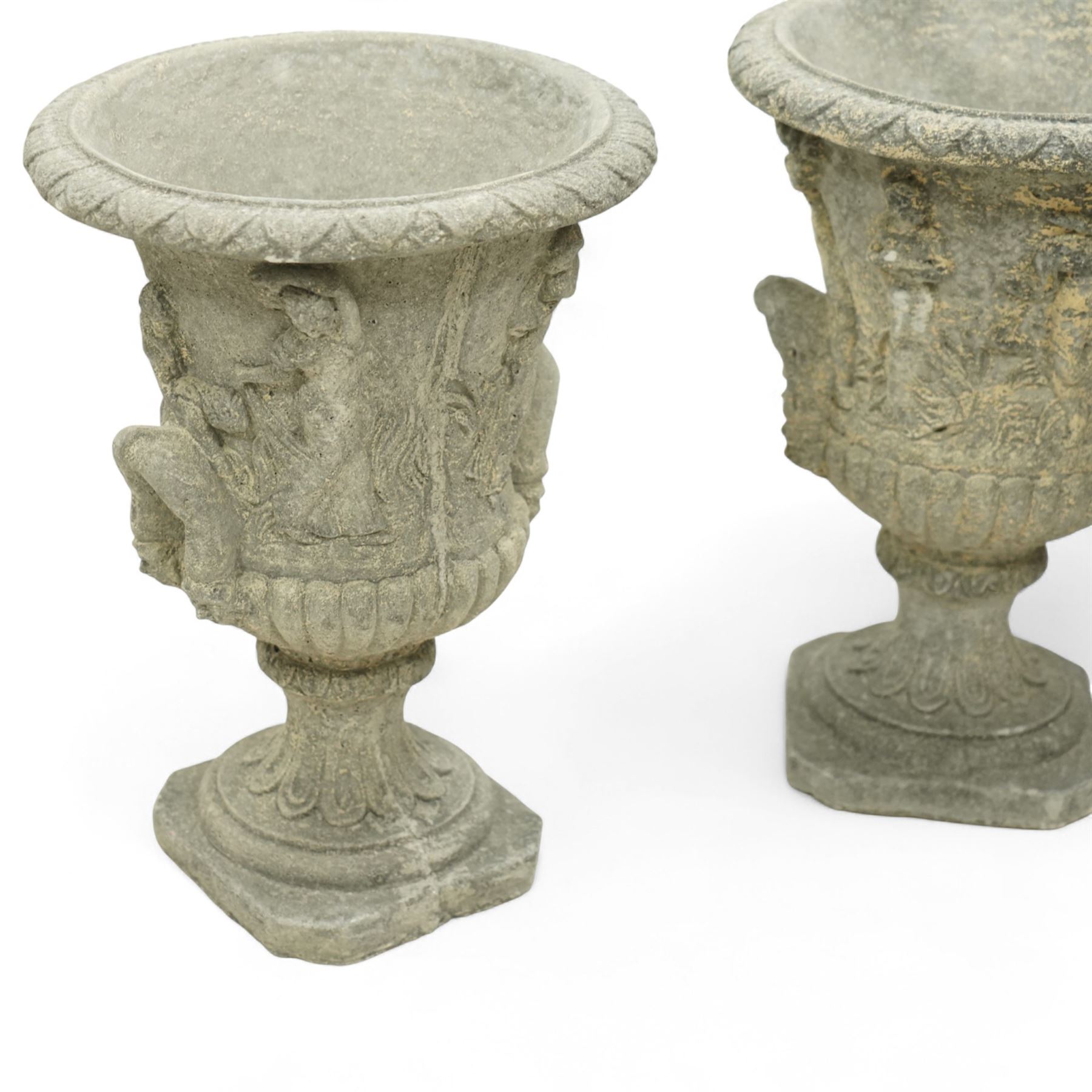Late 20th century set of four composition stone campana urns, each with everted rim over acanthus and mask relief decoration, tapering to a fluted socle on square plinth base