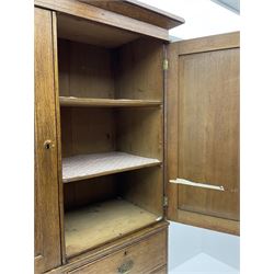 Early 19th century oak linen press cupboard, the projecting cornice over two panelled doors enclosing shelves, two short and two long drawers below, bracket feet