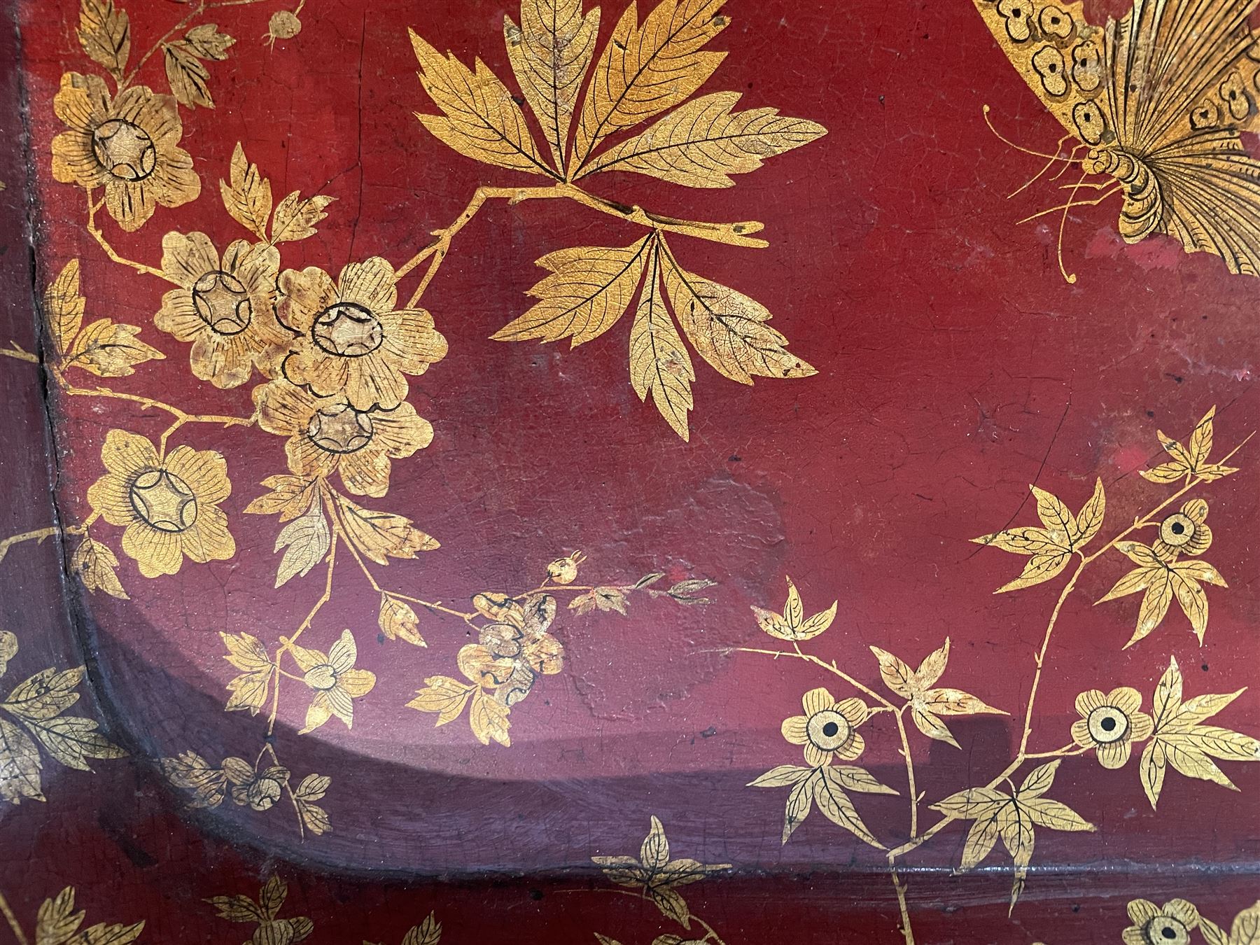 Early 19th century red lacquered papier-mâché tray by Clay of King Street Covent Garden, of rounded rectangular form, painted in gilt with large foliate sprays and butterflies, impressed verso CLAY KING ST COVENT GARDEN, W66.5cm D48.5cm
