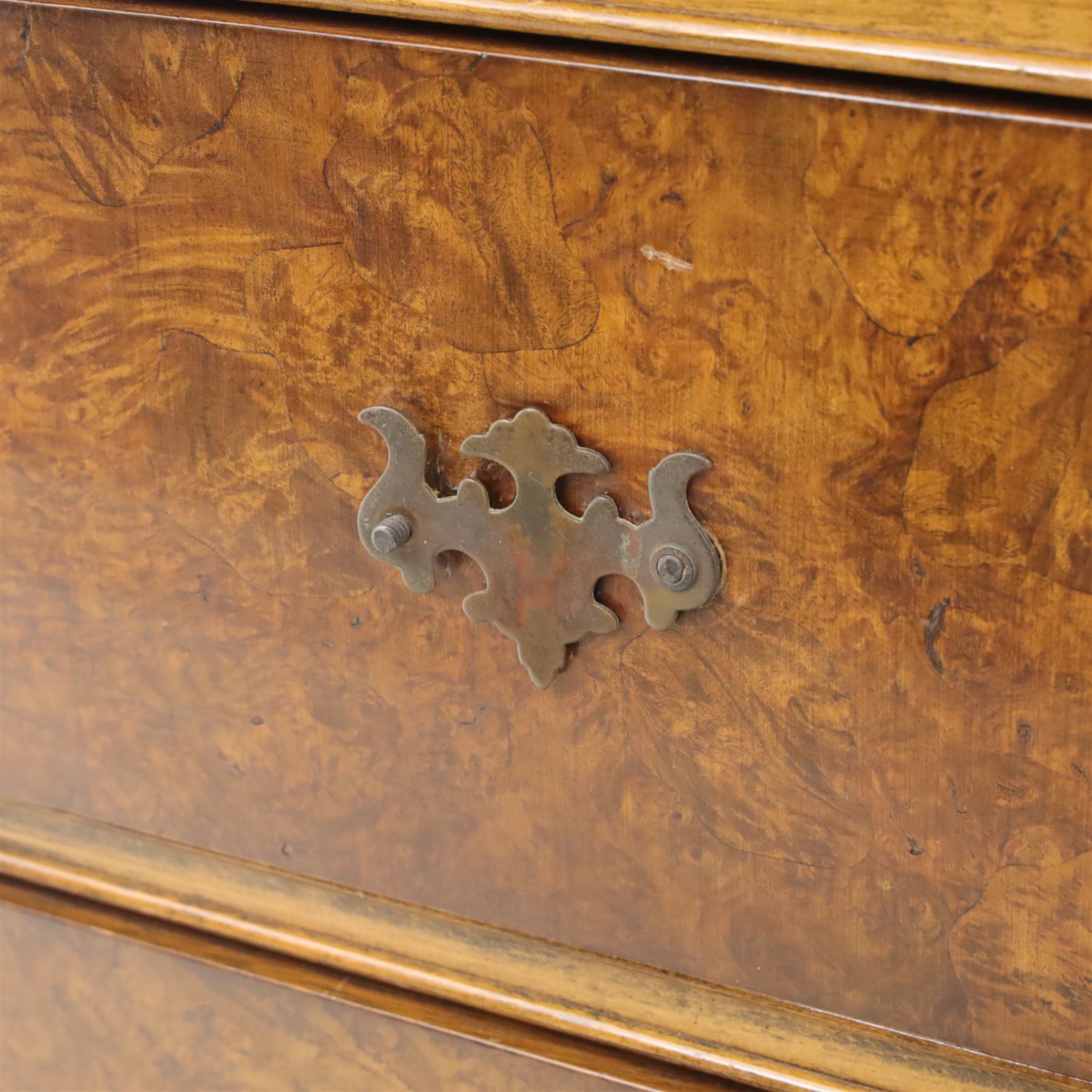 Georgian style walnut chest on stand, the figured top section fitted with four long drawers above a further drawer on the base, brass swan-neck handles, on turned legs joined by shaped stretchers with bun feet
