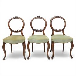 Victorian mahogany dining suite, oval tilt top dining table raised on a quatriform base with paw feet, together with a set of six balloon back dining chairs with green upholstery with cabriole legs 