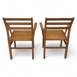 Treske of Thirsk - solid oak refectory dining suite, rectangular top with chamfered edge over trestle base united by a central stretcher, together with six matching slat back dining chairs, including two carvers, with panelled seats and square legs united by stretchers (H 87cm, W 62cm, D 57cm)