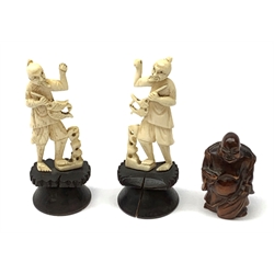 Two carved bone figures, each modelled as a fisherman with catch, overall H9cm, together with a Japanese wooden Netsuke modelled as a hotei, signed beneath, H5cm. 