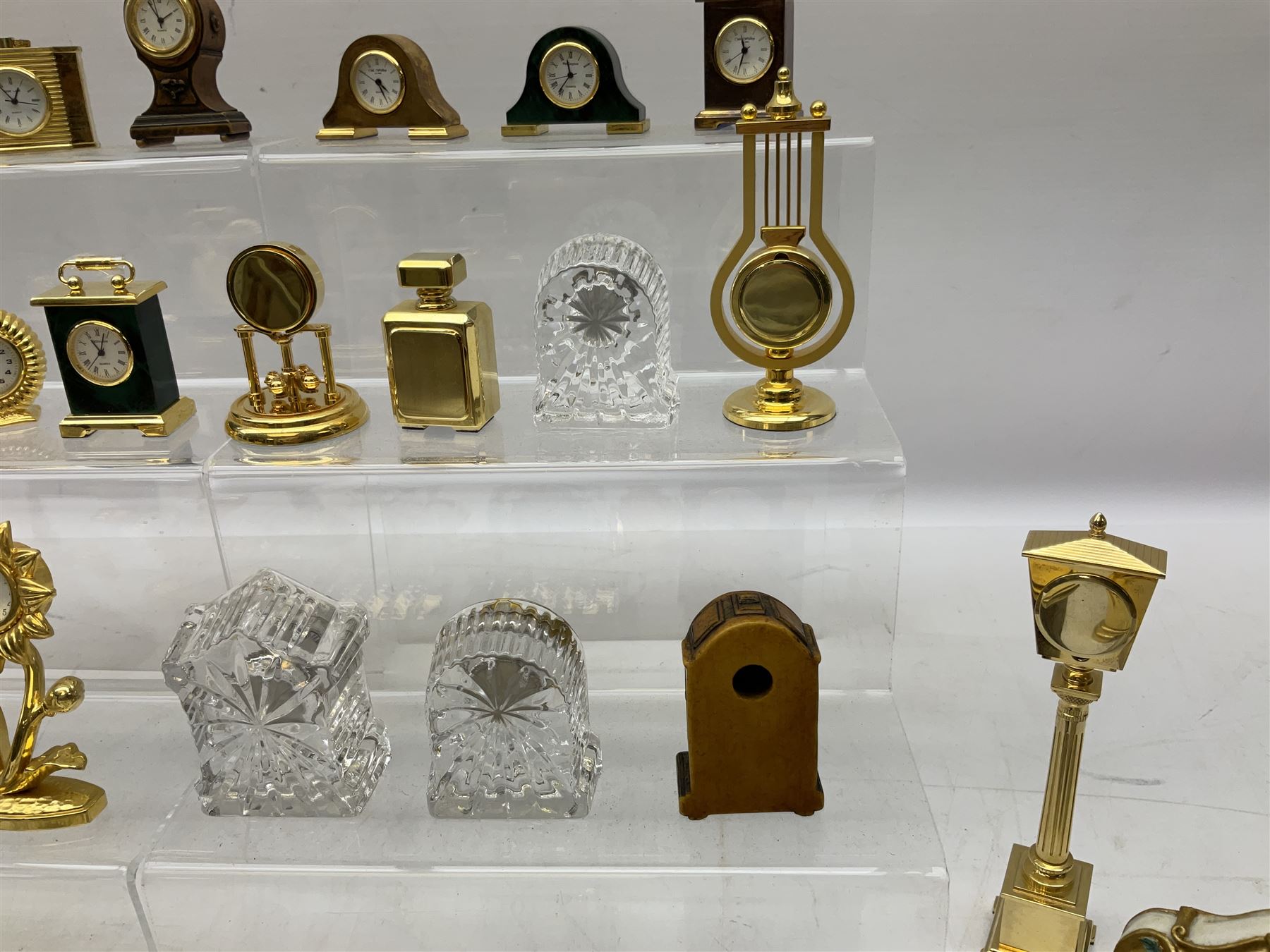Collection of miniature clocks, predominantly with quartz movements, to include example modelled as an armchair, Edinburgh crystal glass example, clock modelled as a flower, sewing machine etc