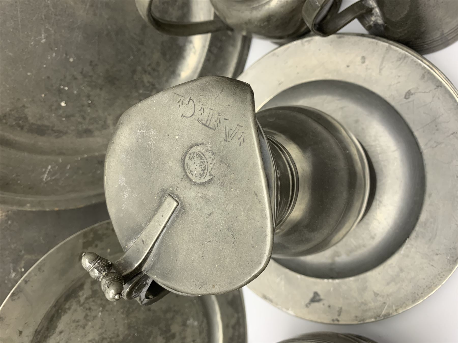 Collection of 18th and 19th century pewter, comprising two chargers, eight large plates, twenty six smaller plates, two bowls, three lidded measures, two jugs, tappit hen, and tankard, the plates with various marks and touch marks, including pseudo 'hallmarks', largest charger 37cm, large plates D30cm, smaller plates D24.5cm, tappit hen H26.5cm