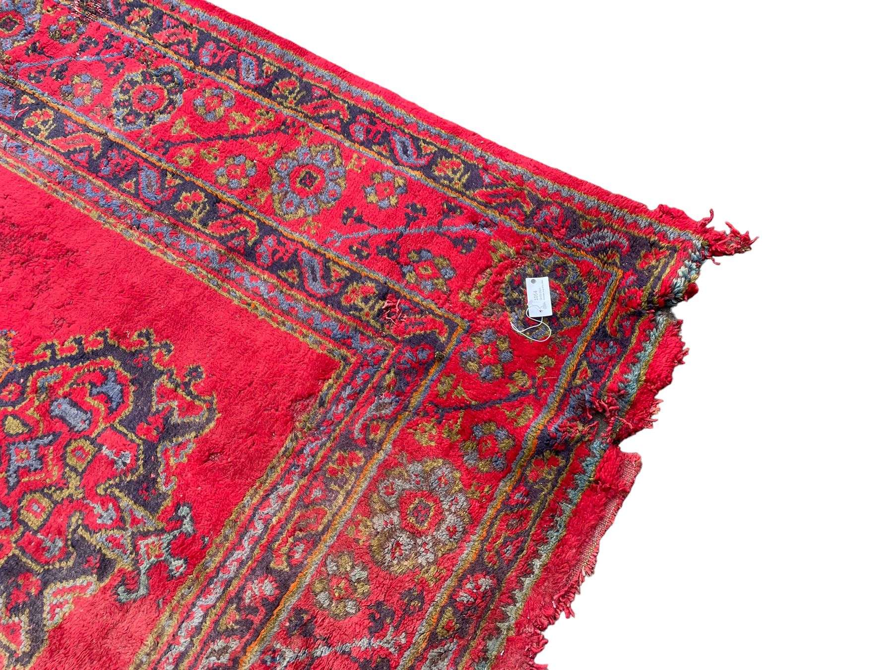 Early 20th century Western Anatolia Turkish Oushak crimson ground carpet, the field decorated with rows of Herati and Palmette medallions, the main border decorated with stylised flower head motifs within guard stripes