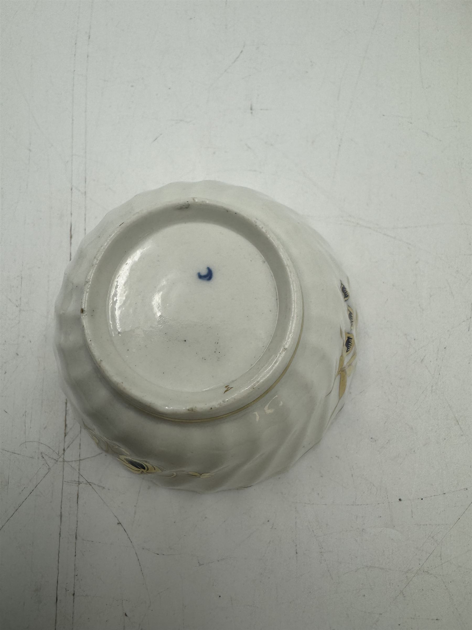 18th century Caughley blue and white sparrow jug, decorated in the Mother and Child pattern, circa 1780-1790, with underglaze C mark beneath, H9cm, together with a Worcester coffee cup, circa 1785 painted with floral sprays in underglaze blue and gilt, with crescent mark beneath, and a Caughley trio of tea cup, tea bowl and saucer, each of moulded wrythen fluted form and decorated with gilt and blue sprigs and bands, each with crescent mark beneath, (5)